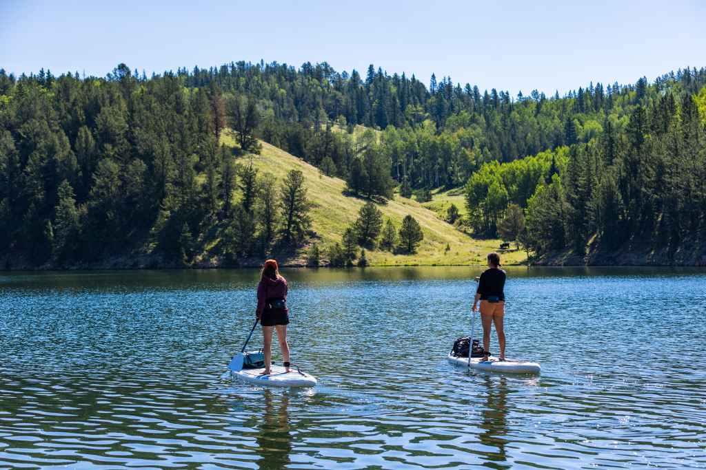 Young couple enjoys a day of lake paddleboarding on their Kokopelli Chasm Lite inflatable paddleboards