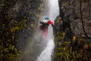 Man hiking while wearing his rolled compacted Rogue-Lite Packraft on his back