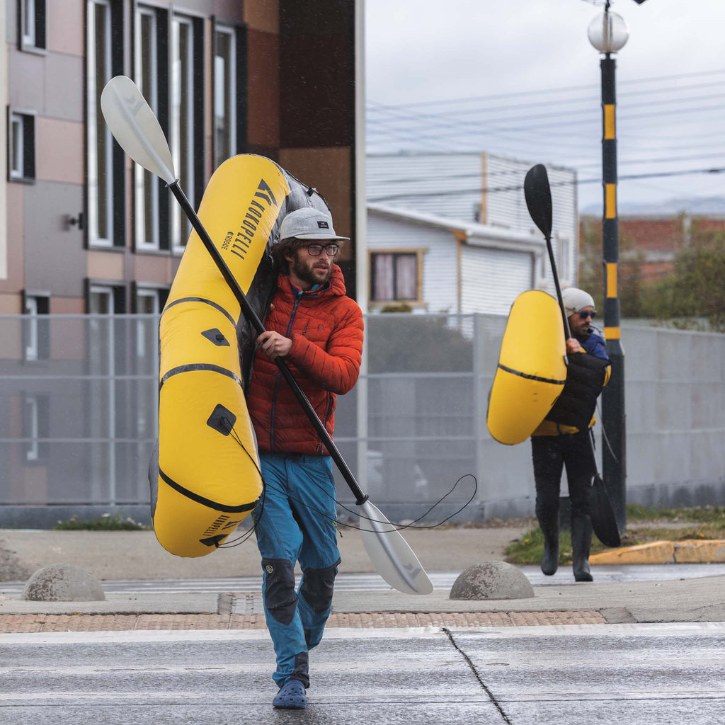 Two men holding Rogue-Lite Packraft in town setting